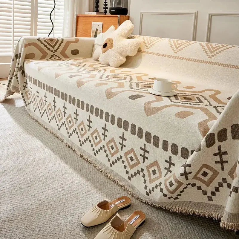 Cobertor decorativo boho com estampa geométrica e borlas.