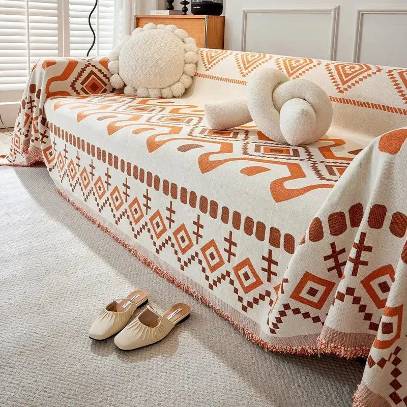 Cobertor decorativo boho com estampa geométrica e borlas.