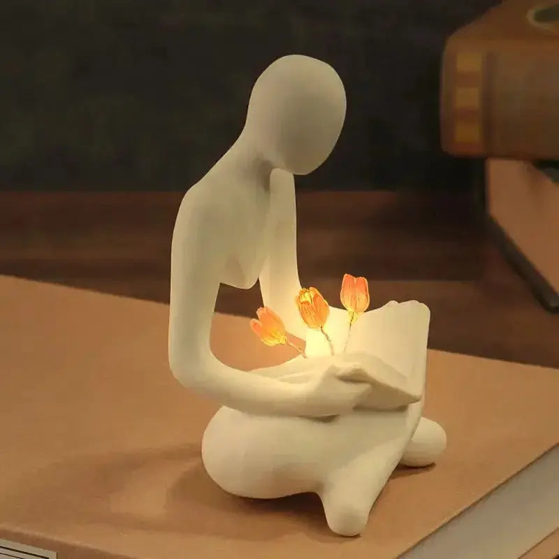 Estatueta Decorativa Pessoa Lendo com Flores Iluminadas Amaritta